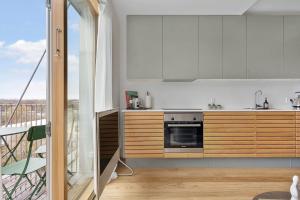 a kitchen with white cabinets and a balcony at Modern & Stylish Apartment with Private Balcony in Aarhus +29 photos