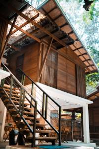 a wooden building with a staircase in front of it at Alun Hostel in San Felipe