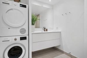 a white laundry room with a washing machine and a sink at Modern & Stylish Apartment with Private Balcony in Aarhus