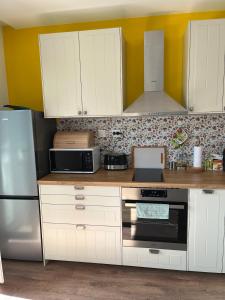 a kitchen with white cabinets and a black oven at Green view 180 in Troyan +22 photos