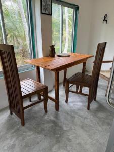 a wooden table with two chairs and a bowl on it at Coconut Villa in Bentota