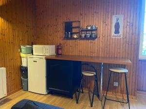 a kitchen with a counter with a microwave and a refrigerator at Studio vintage in Parthenay