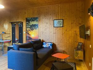 a living room with a blue couch and a table at Studio vintage in Parthenay