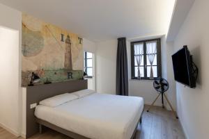 a bedroom with a white bed and a television at Residence La Torre con private park in Trieste