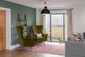 a living room with two green chairs and a couch at Brockview House - Eco 4 bed in Holcombe