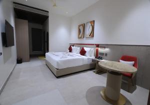 a hotel room with a bed and a table at Antra Luxe in Anumalkudūru +5 photos