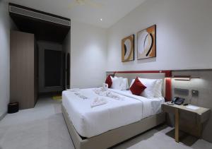 a bedroom with a large white bed with red pillows at Antra Luxe in Anumalkudūru