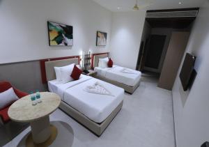 a hotel room with two beds and a table at Antra Luxe in Anumalkudūru