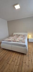 a bed in a room with a wooden floor at Apartmán Na Polabí 2 in Mělník