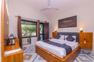 a bedroom with a large bed and a window at Tripp Jim Corbett A River Access Resort in Marchula