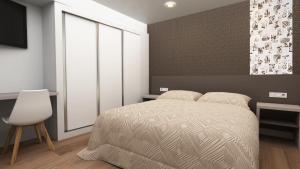 a bedroom with a bed and a chair and a window at Climia 2Sleep Apartments in Benidorm