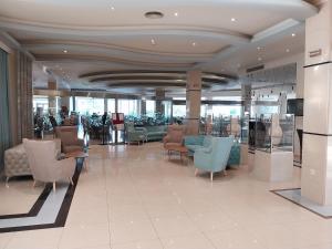 a lobby with chairs and tables in a building at Lydia Maris Resort & Spa in Kolymbia +77 photos