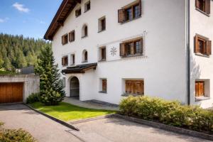 a white house with a driveway in front of it at Laax Cozy Apartment - Ski Bus - Fireplace in Laax
