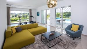 a living room with a yellow couch and a table at Villa Soderini in Dubrovnik