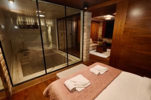 a bedroom with a bed and a glass shower at Aqua Spa Lux in Novi Pazar +17 photos