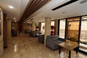 a waiting room with couches and tables and windows at Aqua Spa Lux in Novi Pazar