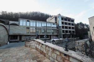 a building with a stone wall in front of a building at Aqua Spa Lux in Novi Pazar