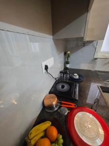 a kitchen counter with a plate of fruit on a table at Yogqala Homestay 04 in Jaipur +5 photos