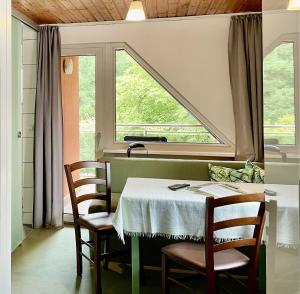 ein Esszimmer mit einem Tisch und einem Fenster in der Unterkunft Hotel Barbara in Warmensteinach + 35 Fotos
