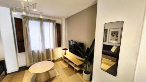 a small living room with a table and a television at Apartamentos Carmen del Turia in Valencia