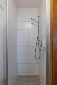 a bathroom with a shower with white tiles at Pension Krone in Schwäbisch Gmünd +10 photos