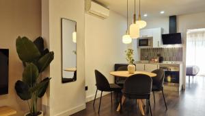 a living room with a table and chairs and a kitchen at Apartamentos Carmen del Turia in Valencia