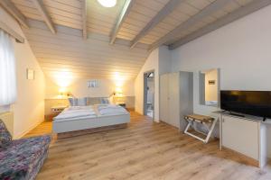 a bedroom with a bed and a flat screen tv at Pension Krone in Schwäbisch Gmünd