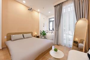 a bedroom with a large white bed and a bathroom at Sai Gon Stay-Hi-Tech Park Collection in Ho Chi Minh City
