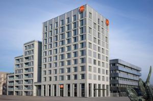a tall white office building with two at You Hotel Amiens - Handwritten Collection in Amiens