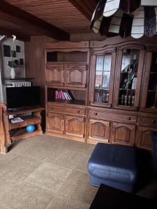 ein großes hölzernes Unterhaltungsmöbel im Wohnzimmer in der Unterkunft Hotel Bollerott in Selm