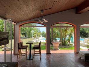a living room with a table and chairs and a pool at Villa Lorivita in Bevazzana