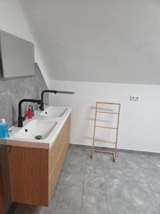 a bathroom with a sink and a wooden chair at Lux-Bau - Stilvoll und modern in Schmelz