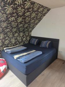 a blue couch with pillows in a room with a wall at Lux-Bau - Stilvoll und modern in Schmelz
