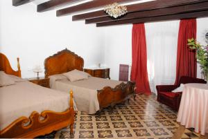 a hotel room with two beds and a chair at Ca la Paula in Pla del Panadés