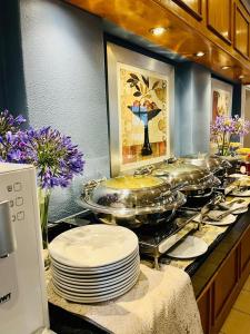 a buffet with plates and pans on a counter at Road Lodge Isando in Germiston +25 photos