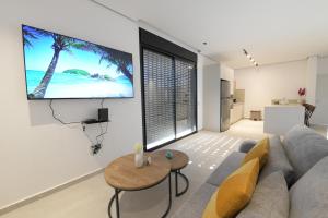 a living room with a couch and a tv on the wall at Cohav Sea View in Eilat