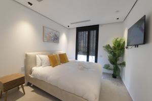 a white bedroom with a bed and a window at Cohav Sea View in Eilat +58 photos
