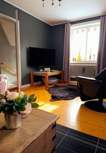 a living room with a flat screen tv and a table at Hus Fee in Fredriksberg