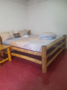 a bed with a wooden frame in a room at BAGIYA Hut RESORT in Billi