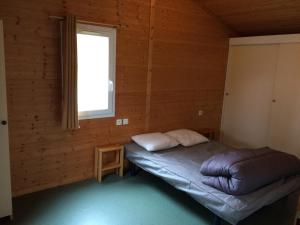 una camera da letto con un letto in una stanza di legno di Camping Les Lupins a Seppois-le-Bas