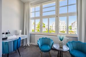 a room with blue chairs and a table and a window at Strandvilla Glückauf in Binz