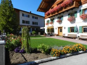 a garden in front of a building with flowers at Pension Johannes in Bach