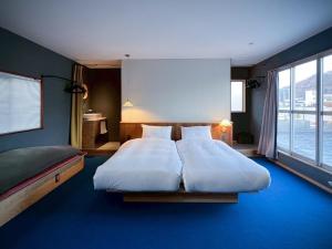 a bedroom with two beds and a large window at Lemonsea Onomichi in Onomichi