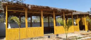 a large yellow building with a straw roof at BAGIYA Hut RESORT in Billi