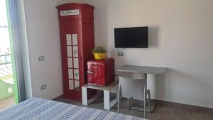 a room with a small desk and a red refrigerator at Civitas Locanda in Ghedi