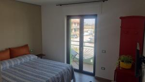 a bedroom with a bed and a sliding glass door at Civitas Locanda in Ghedi
