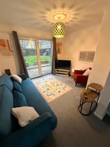 a living room with a blue couch and a window at Spacious House - Parking - Pool Table in Balderton
