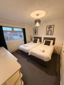a bedroom with two beds and a window at Spacious House - Parking - Pool Table in Balderton