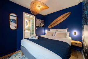 a bedroom with a large bed with blue walls at Air Nomad • Sydney in Valenciennes