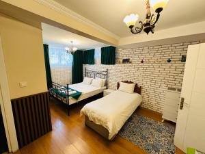a bedroom with two beds and a brick wall at Stone Home Apart in Istanbul